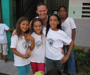 Volunteer with four cbc students in front of classroom building