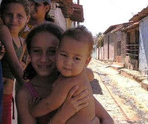 family in the shade of a wall in dirt street