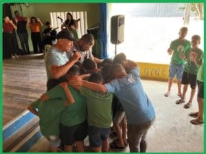 Photo of Marc praying with staff and children at CBC.