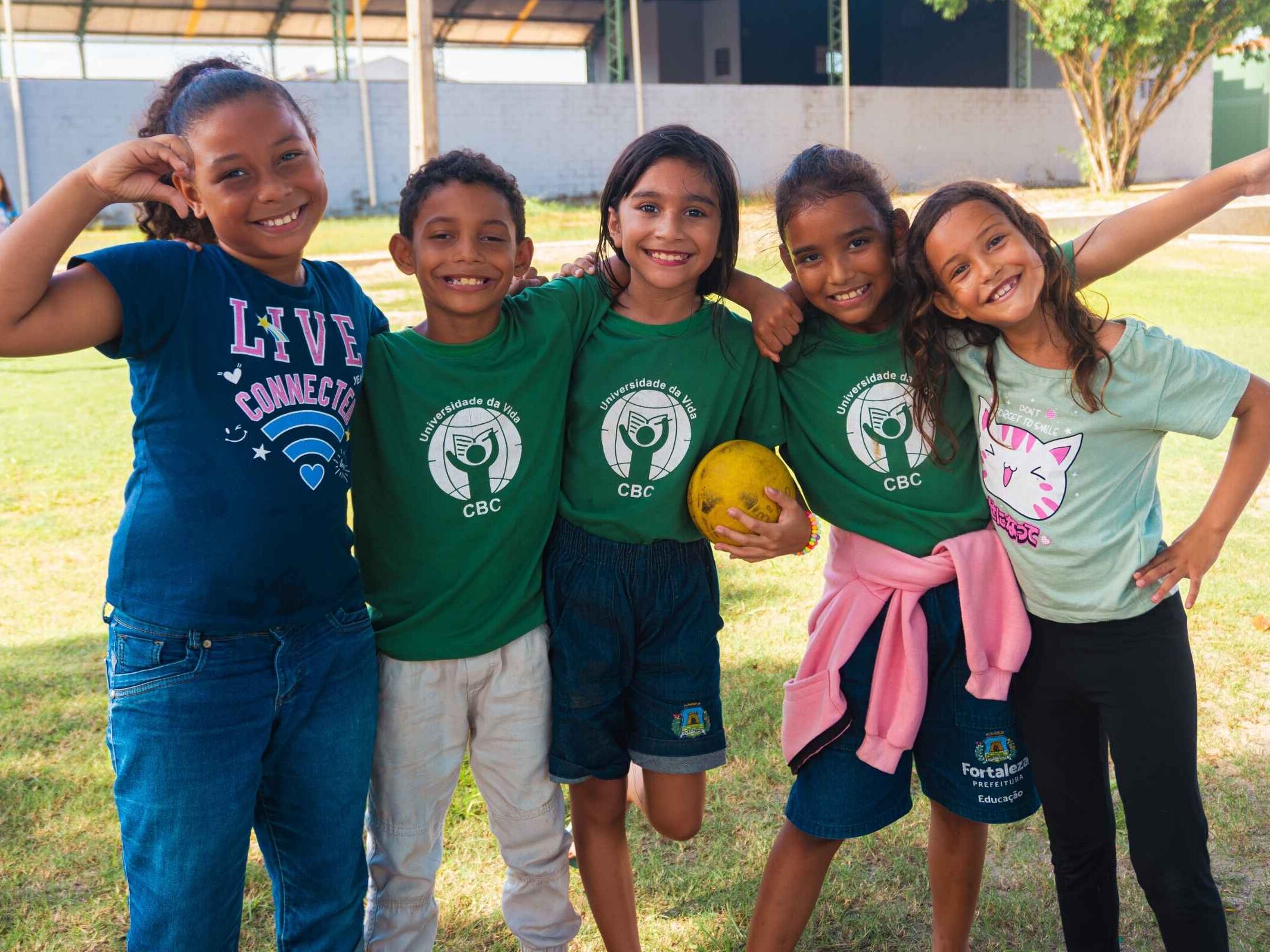 children at CBC standing line with smiles leaning against each other