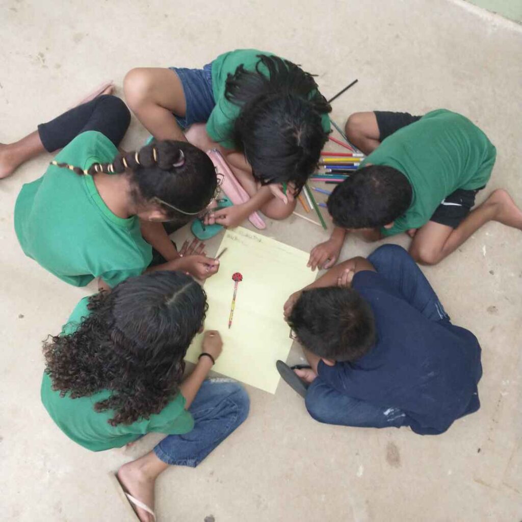 children at CBC in a circle looking at paper