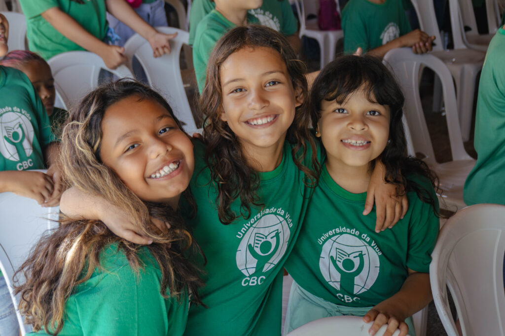 3 smiling students at the project