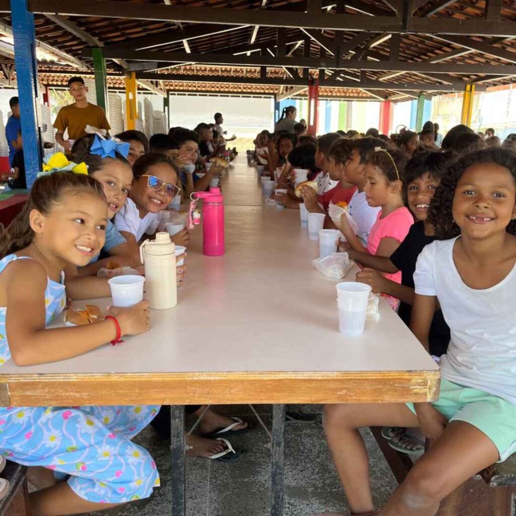 CBC students smiling and sitting at a table eating a meal together.